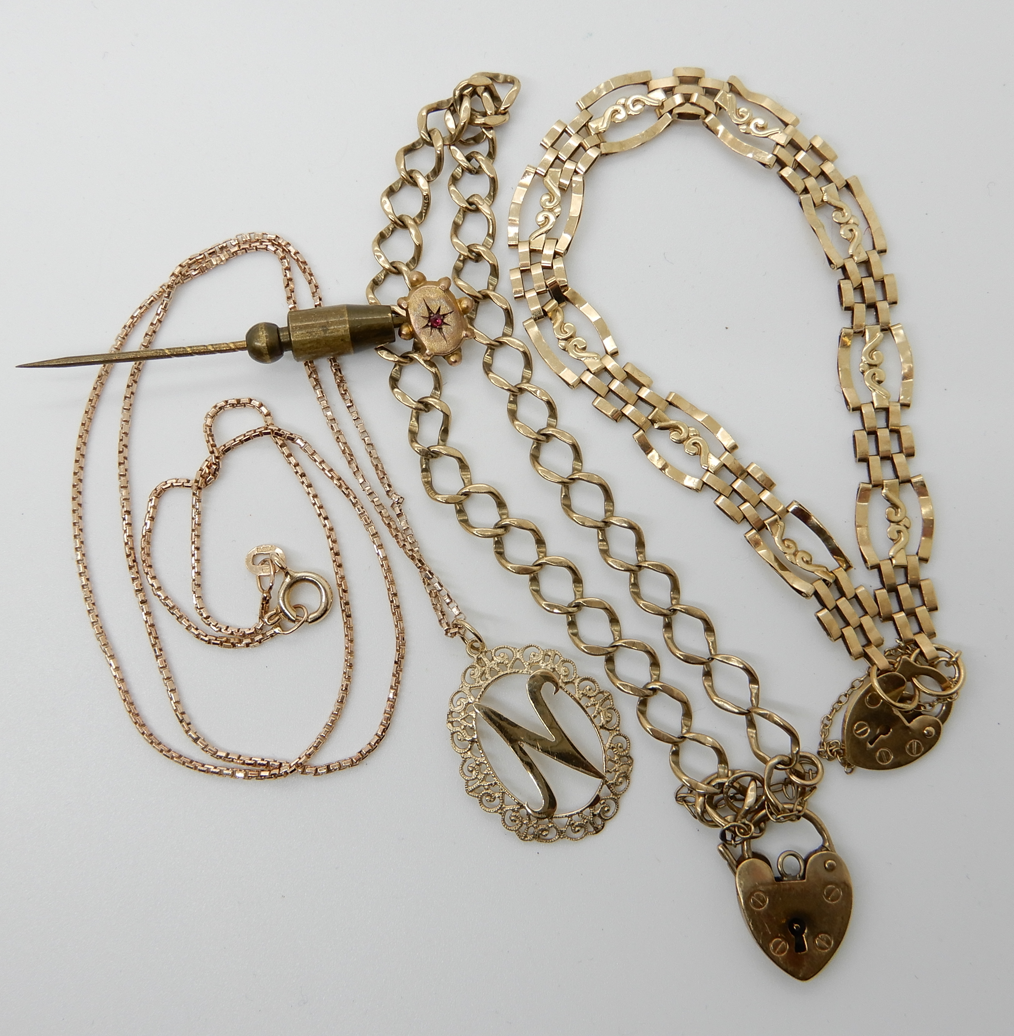 A 9ct gold chain with a 'N' pendant length 46cm, a 9ct gold fancy link gate bracelet with heart