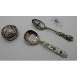 A lot comprising two sterling silver and enamel serving spoons and a sterling silver pill box with