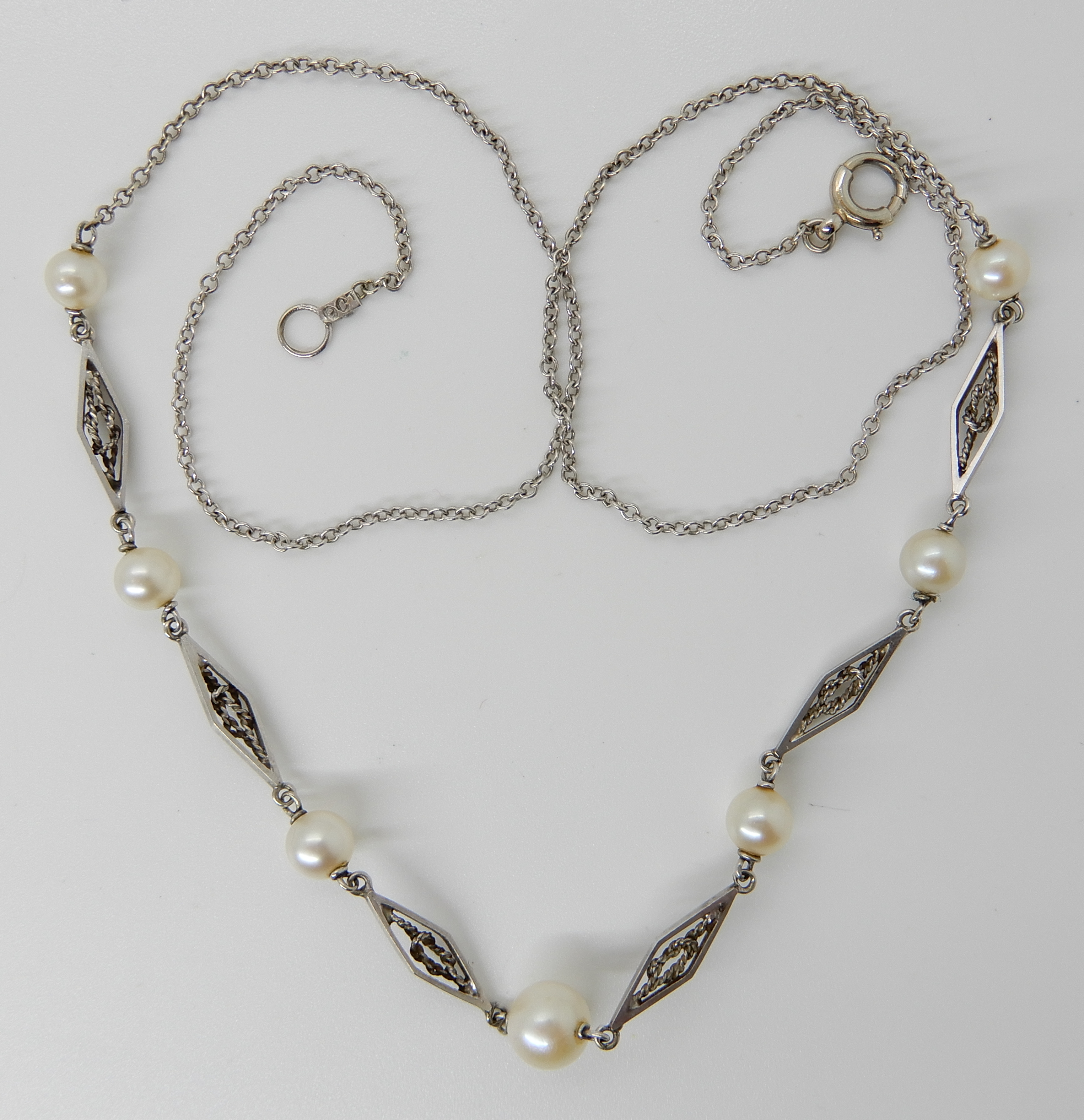 A 9ct white gold pearl set chain with lovers knot detail links, length 43cm, weight 3.5gms Condition