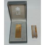 A yellow-metal Dunhill lighter in case and a white-metal Dunhill lighter (2) Condition Report: