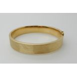 A 14k gold brushed textured bangle, inner dimensions 6.3cm x 5.6cm, weight 25gms Condition Report: