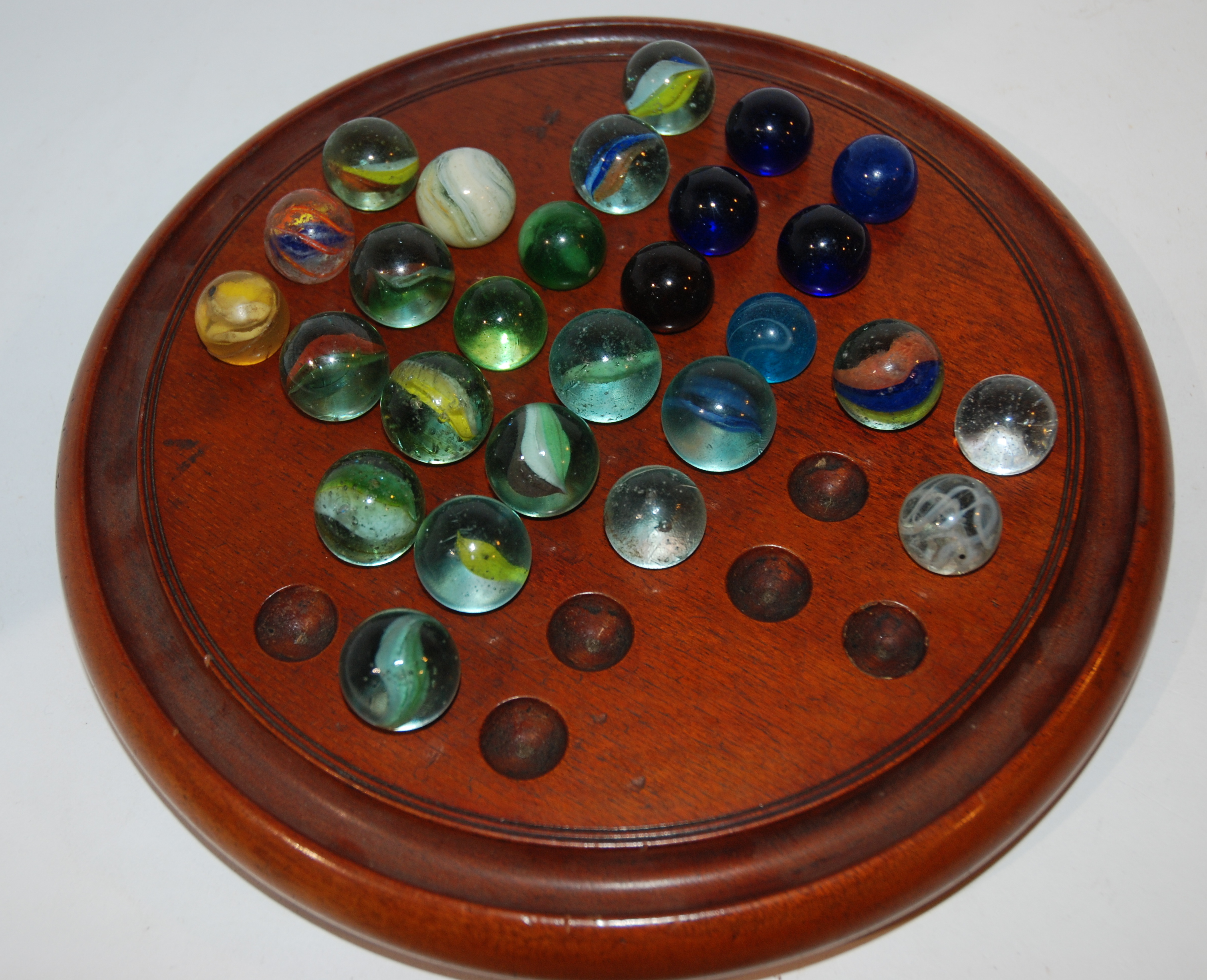 A collection of marbles and solitaire board, 26cm diameter Condition Report: Available upon request