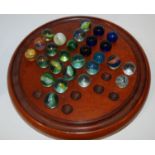 A collection of marbles and solitaire board, 26cm diameter Condition Report: Available upon request