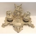 A Victorian cast iron desk stand, decorated with a winged maiden and griffins, painted white