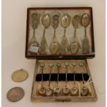 A lot comprising a cased set of six white metal oriental style teaspoons, a cased set of six