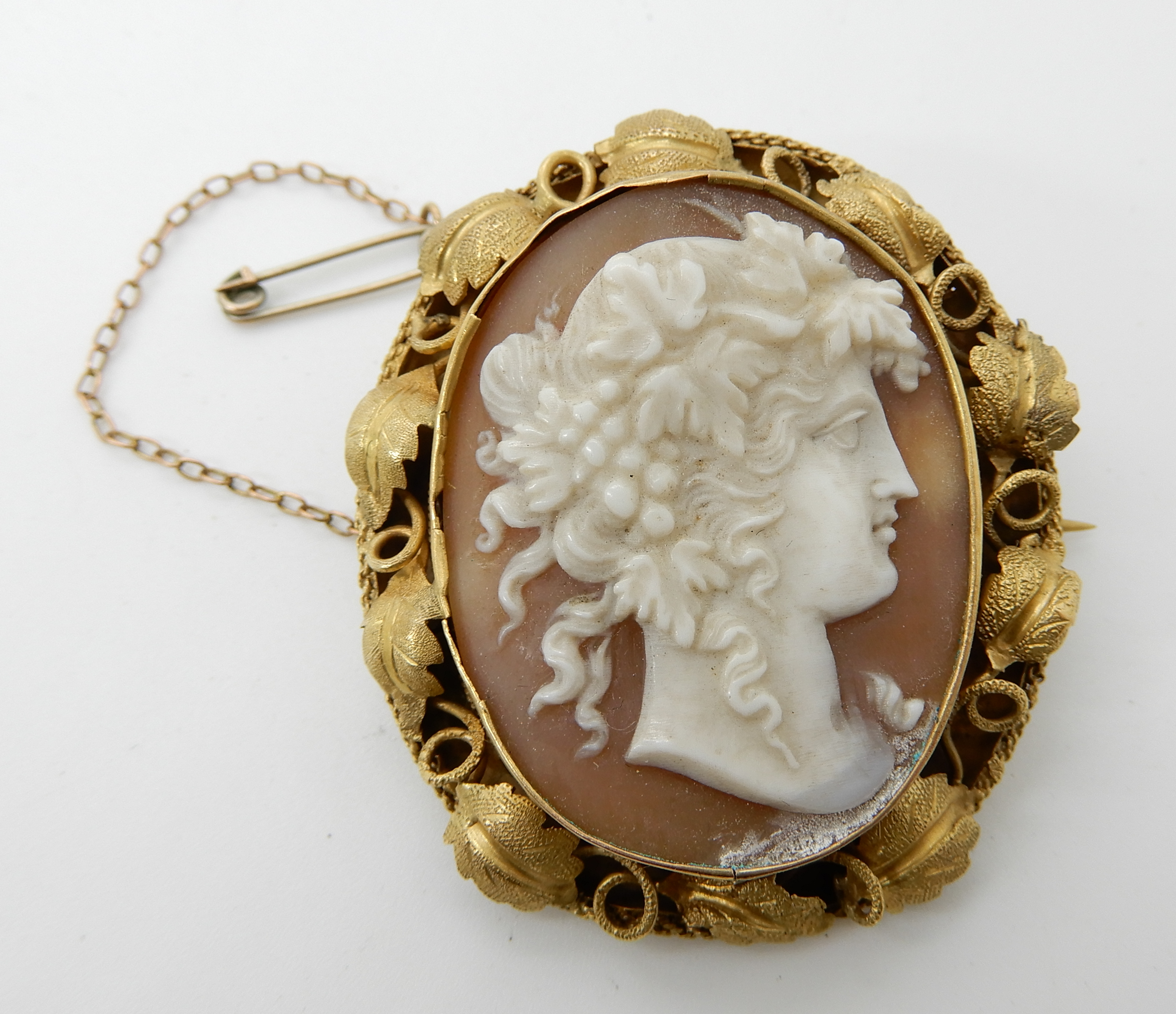 A well carved shell cameo of a maiden in a yellow metal decorative mount, 4.6cm x 4cm, weight 14.