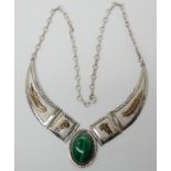 A silver Navaho design necklace with gold plated detail further set with malachite, by Mark Yazzie