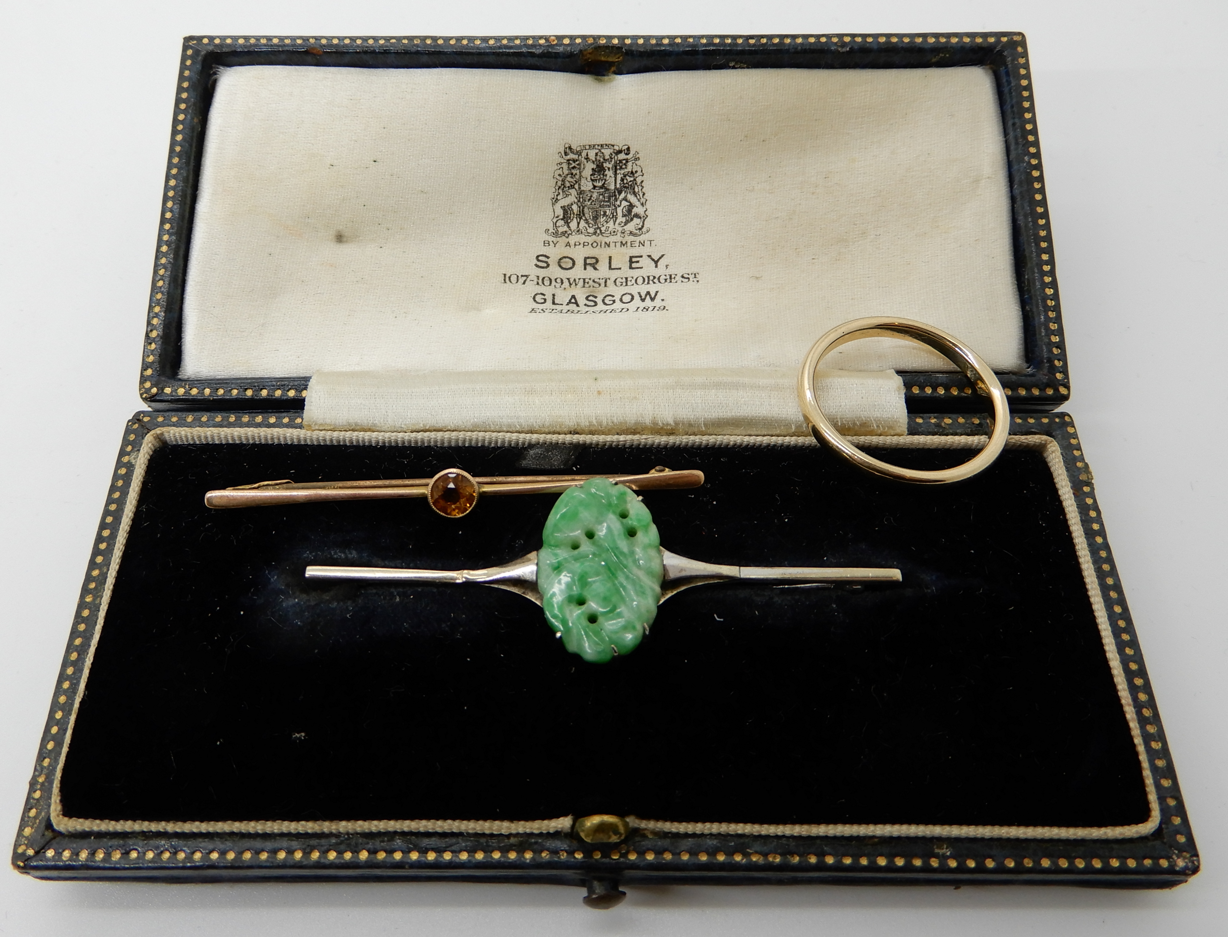 A 9ct white gold Chinese green hardstone set bar brooch, length 5.7cm, hardstone 17mm x 11mm, a