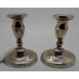 A pair of silver candlesticks, Sheffield 1909, 14cm high, weighted Condition Report: Available