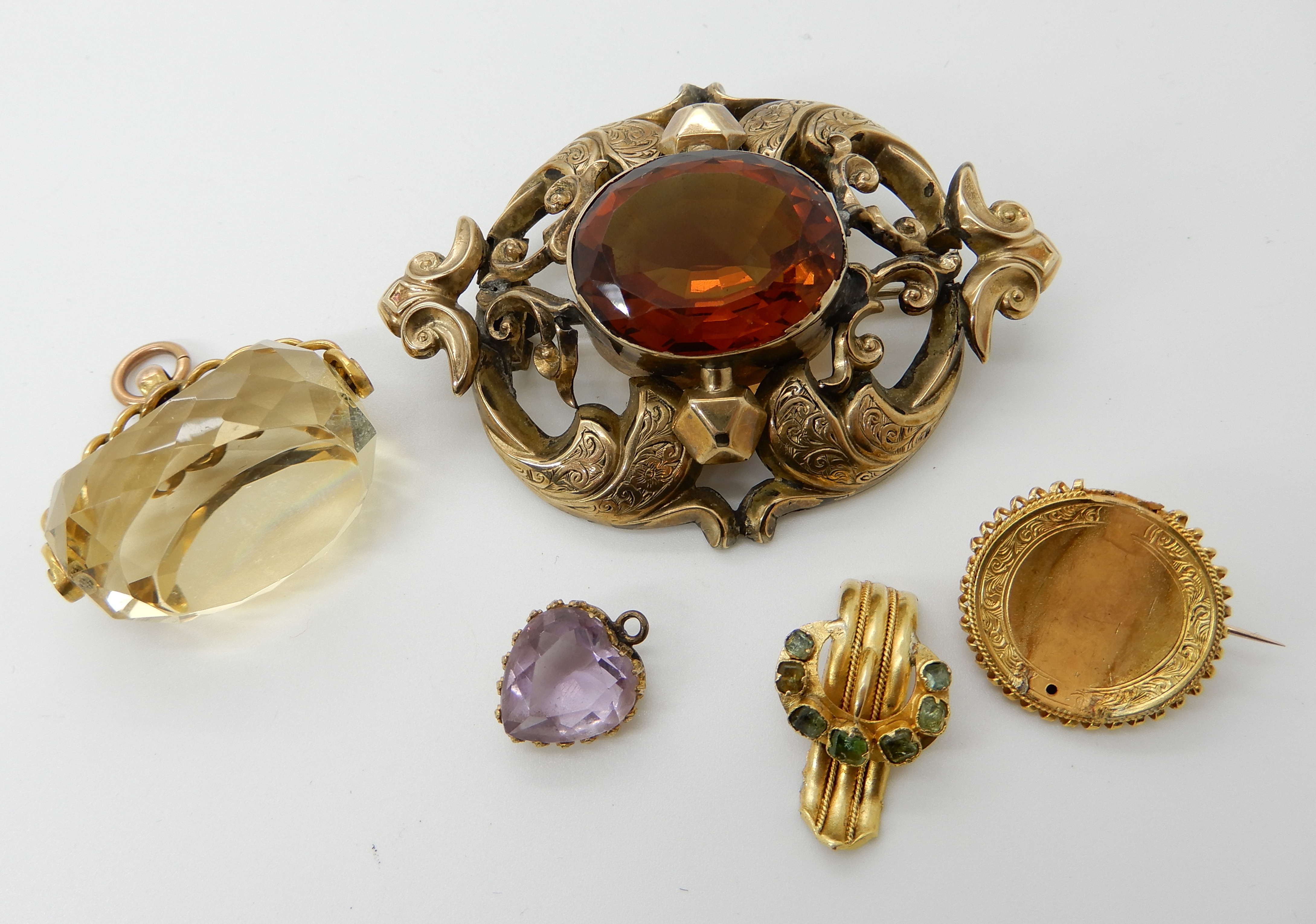A 9ct gold citrine fob seal, a yellow metal brooch set with green gems, a yellow metal amethyst