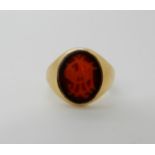 A bright yellow metal signet ring set with a intaglio monogrammed agate, size K, weight 6.2gms