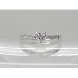 An 18ct white gold heart shaped diamond ring with further diamonds set tot the shoulders,