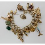 A 9ct gold charm bracelet to include twenty two 9ct and yellow metal charms, weight approx 73.5gms