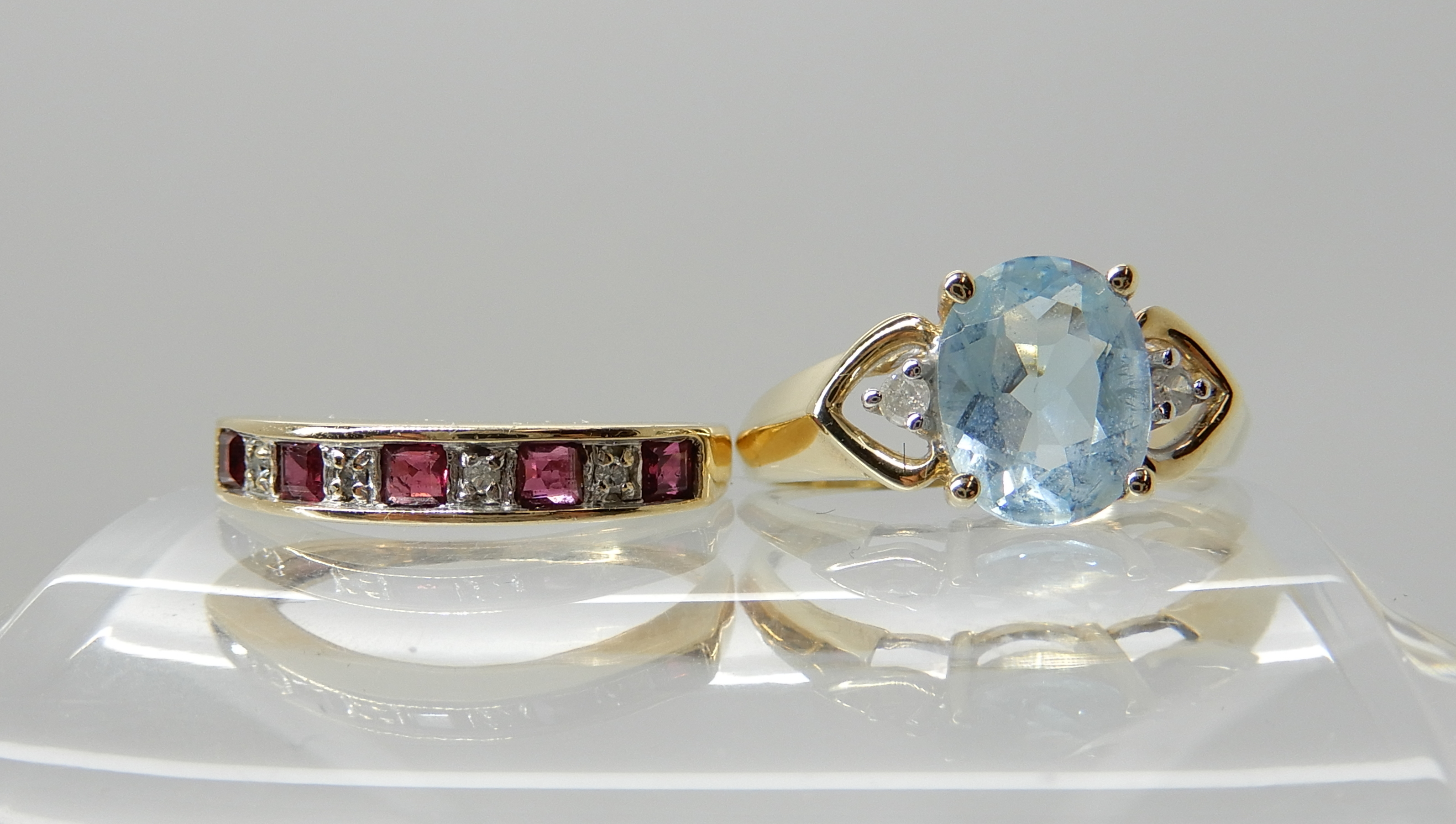 A 9ct ruby and diamond half eternity ring, size M and a 9ct blue gem and diamond ring size M1/2,