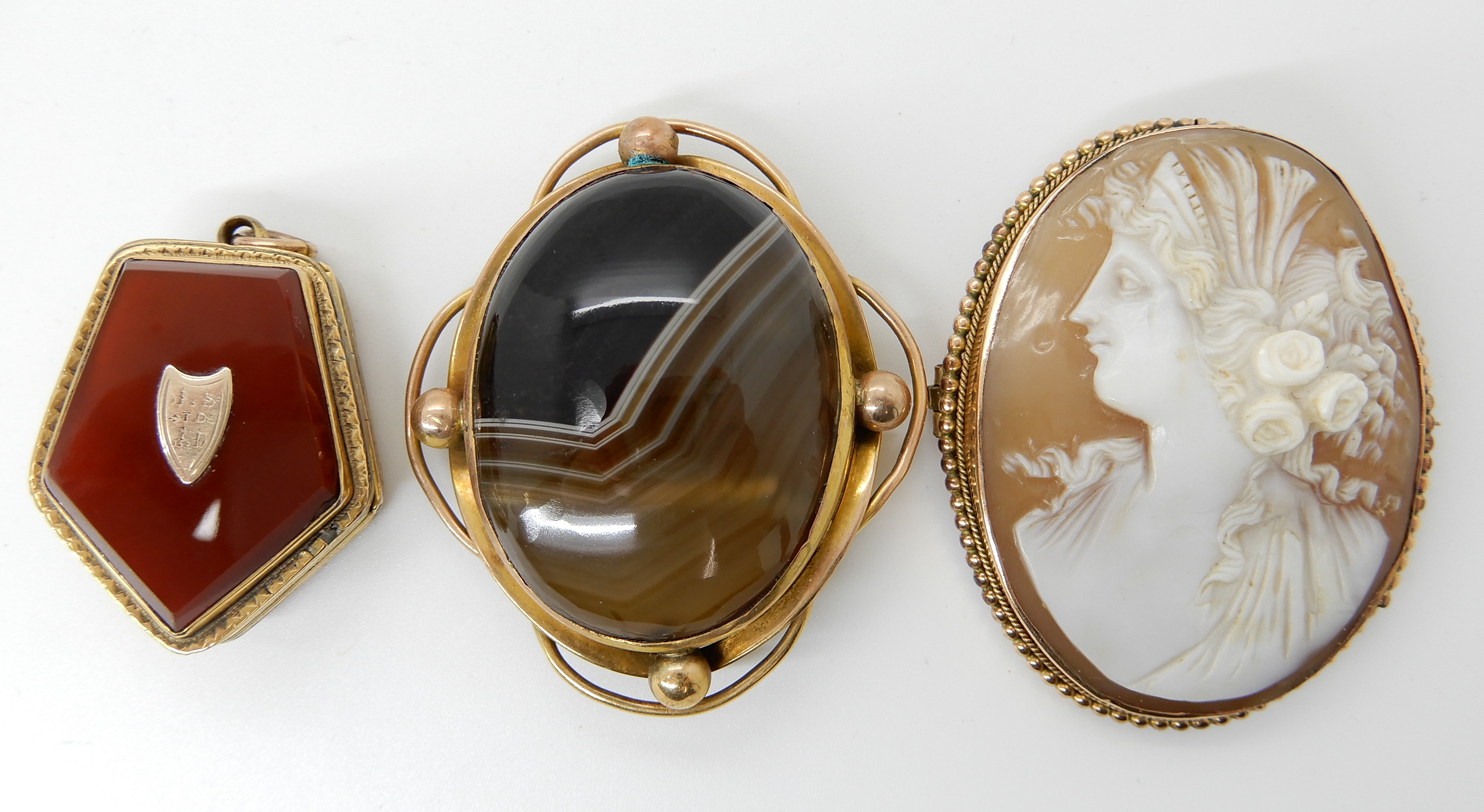 A 9ct cameo brooch, and a yellow metal mounted agate locket and brooch Condition Report: Available