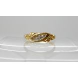An 18ct gold three stone diamond ring with scroll design, hallmarked Birmingham 1899, size N, weight