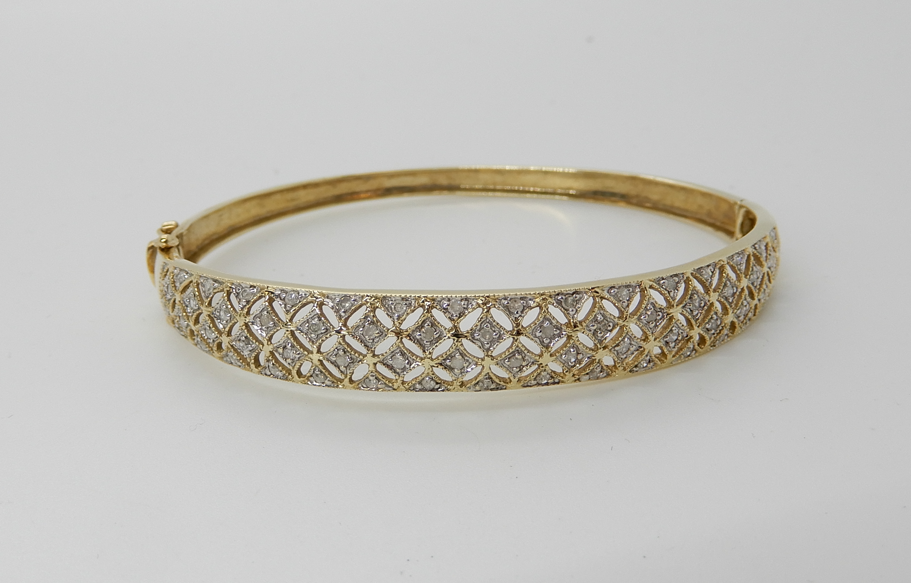 A 9ct gold diamond set pierced bangle, weight 8.8gms Condition Report: Available upon request