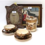 A pair of Satsuma cups and saucers, a pot and cover, a dragon decorated frame and an erotic
