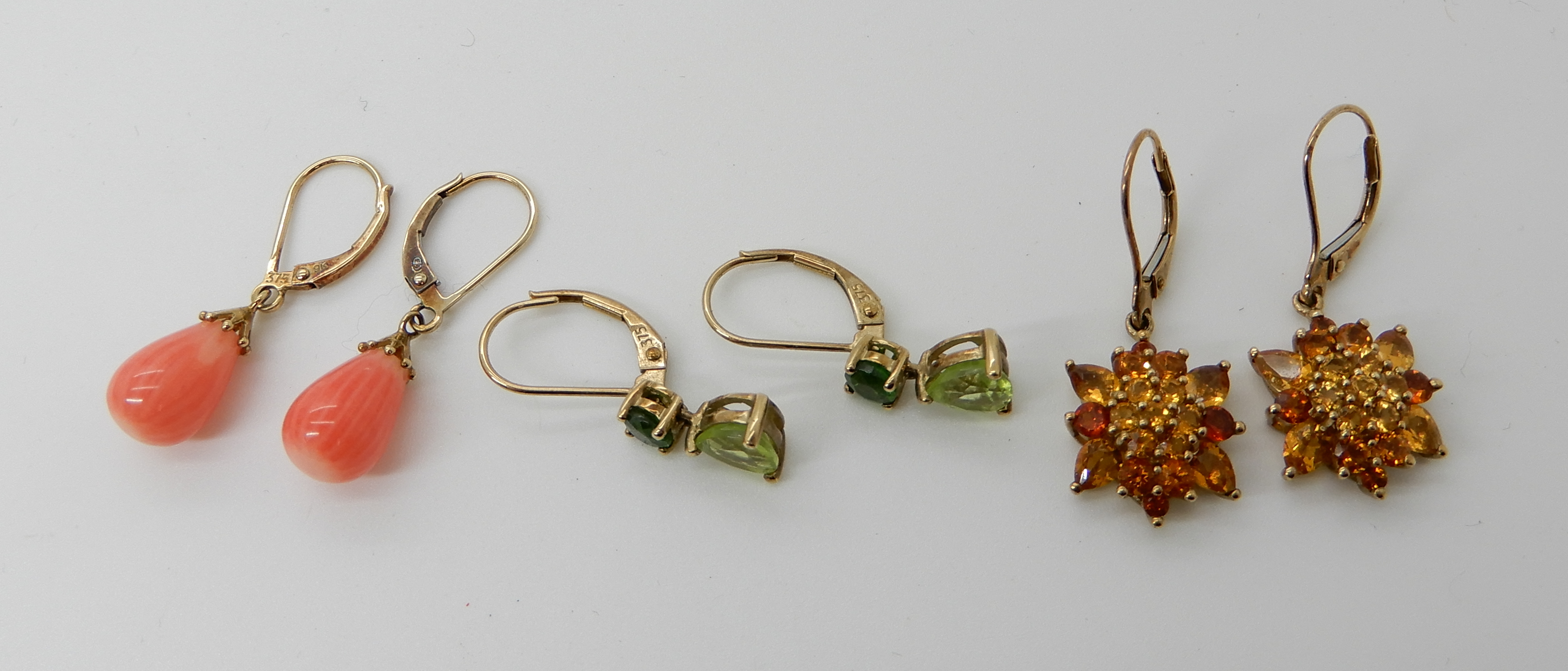 Three pairs of 9ct gold gem set earrings to include peridot, citrine and coral, weight combined 7.