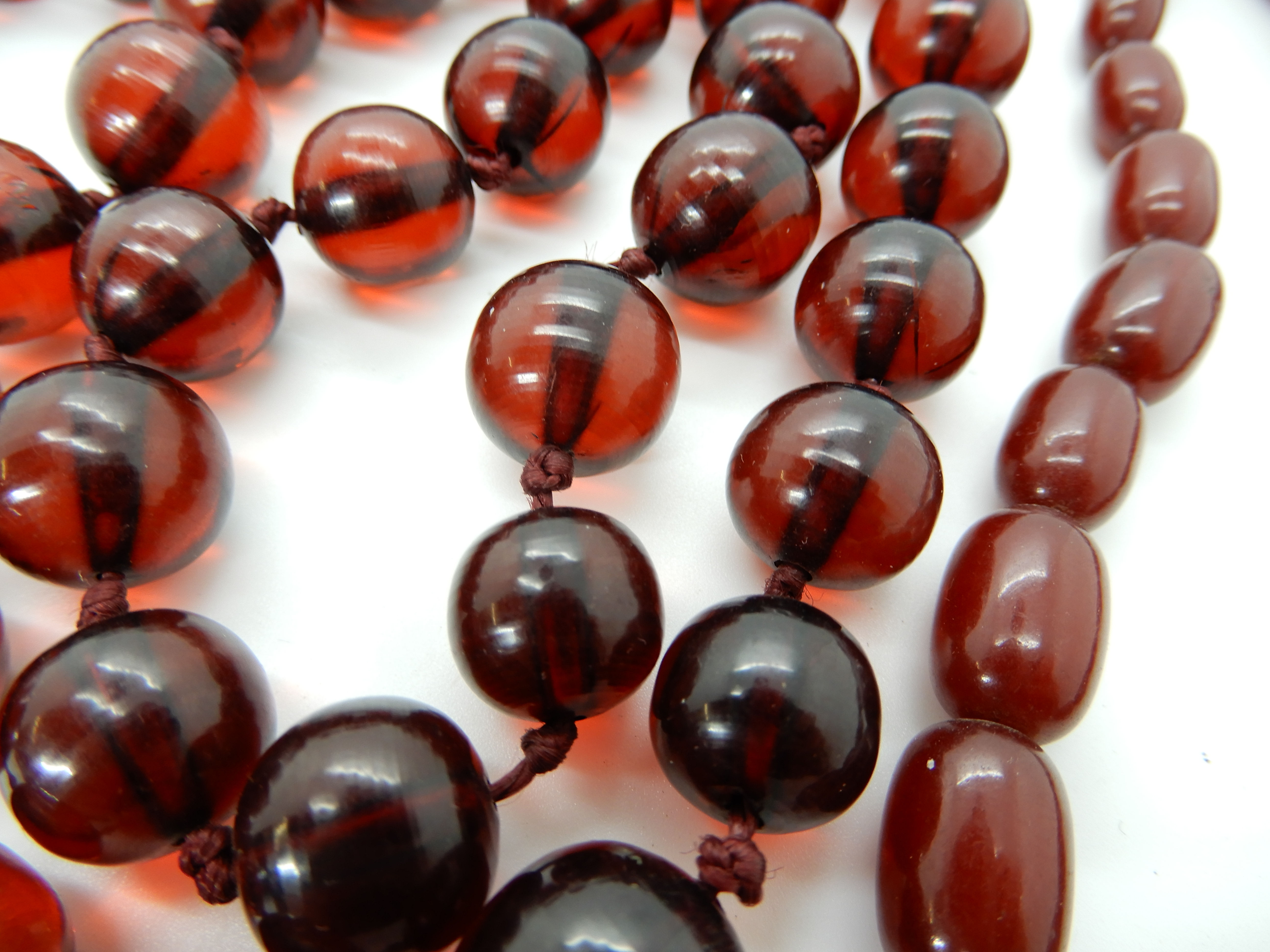 Two strings of cherry amber coloured beads, round beads weight 106.2gms, oval beads weight 25.5gms - Image 3 of 3