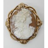 A LARGE WELL CARVED SHELL CAMEO OF A MAIDEN in a yellow metal locket back brooch mount embellished