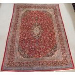 A RED GROUND KESHAN RUG with central medallion and matching spandrels and borders, 392cm x 286cm