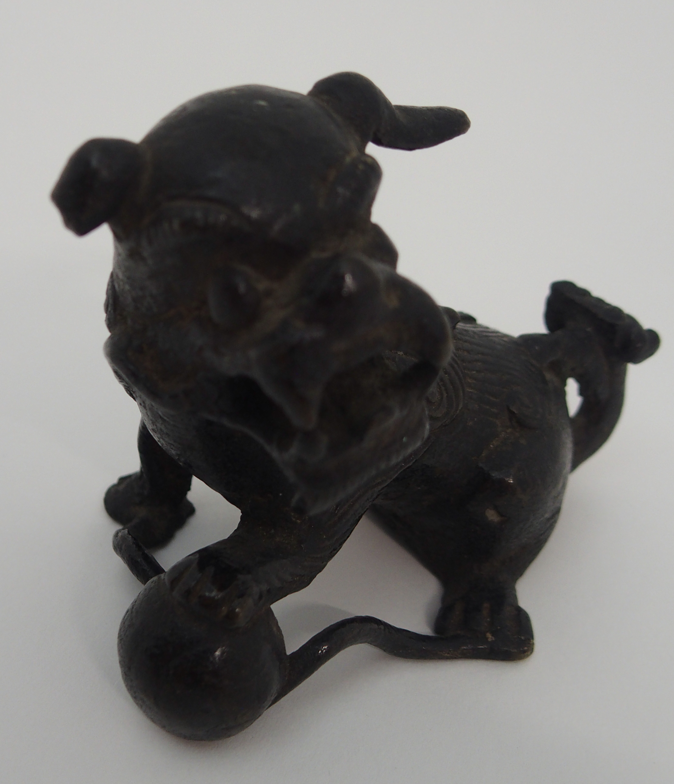 A CHINESE BRONZE SHISHI modelled seated and holding a brocade ball, 17th/18th Century, 6.5cm high - Image 5 of 5