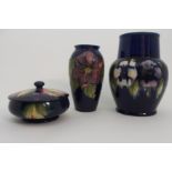 A MOORCROFT PANSY PATTERN VASE the dark blue ground with white and purple flowers, 21.5cm high,