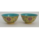 A PAIR OF CHINESE YELLOW GROUND BOWLS painted with peonies and scrolling foliage above a band of