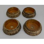 A SET OF FOUR SILVER GILT WINE COASTERS by John Waterhouse, Edward Hatfield & Company, Sheffield