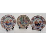 A CANTON FAMILLE ROSE PLATE painted with figures on a pavilion and garden, within a border of