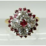 AN 18CT GOLD RUBY AND DIAMOND CLUSTER RING set with four brilliant cut diamonds with a total of
