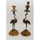 A PAIR OF BRONZE CANDLESTICKS, AFTER THOMAS ABBOTT modelled as cranes with crowns on their necks,