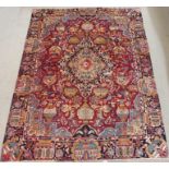 A RED GROUND VINTAGE KASHMAR RUG with unique under earth design with urns and floral designs with