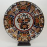 AN IMARI CHARGER painted with a central jardiniere of flowers, within panels of pavilions,