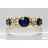 AN 18CT GOLD SAPPHIRE AND DIAMOND RING with decorative scrolled mount, largest sapphire approx 4.