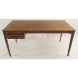 A MID-CENTURY DANISH STYLE ROSEWOOD DESK with shaped frieze on shaped legs with single drawer,