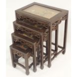 A NEST OF FOUR CHINESE TABLES each with inset glazed tops decorated with hardstone precious objects,