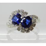 A DIAMOND AND TWIN SAPPHIRE SET RING craftsman made in white metal and set with estimated approx 0.