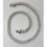 AN 18K WHITE GOLD DIAMOND LINE BRACELET further stamped 750 to the clasp, set with estimated