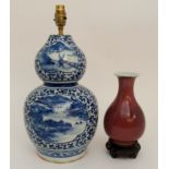 A CHINESE BLUE AND WHITE DOUBLE GOURD VASE painted with ogival and leaf shaped panels of river