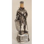 A CONTINENTAL SILVER FIGURE OF A KNIGHT standing in a part suit of armour with sword and shield,