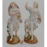 A PAIR OF CONTINENTAL FIGURES OF MAIDENS one modelled holding flowers, the other a a flaming lamp,