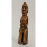 AN AFRICAN LEGA VOTIVE IVORY FIGURE carved with tattooed angular mask head, carved roundels to