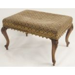 A VICTORIAN WALNUT RECTANGULAR STOOL the padded seat on foliate scroll legs, 42cm high x 70cm wide x