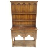 A SMALL OAK DRESSER the plate rack with scalloped cornice above two shelves and above two drawers