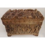 A BENIN HARDWOOD CASKET carved all over with attendants serving The Obi King, 44cm high x 62cm