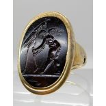 A CLASSICAL THEMED INTAGLIO OF CUPID AND A GRASSHOPPER carved in dark banded carnelian, the