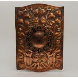 AN ARTS AND CRAFTS COPPER WALL CLOCK with repoussé decoration of stylised foliage with painted black