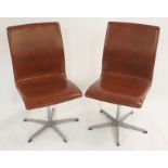 A PAIR OF ARNE JACOBSEN FOR FRITZ HANSEN OXFORD SWIVEL CHAIRS with tan leather seat and back on an